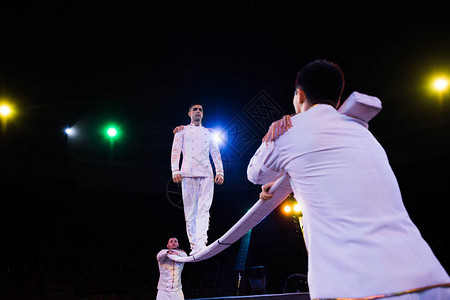 在马戏团中男子附近的杆上平衡的英俊空气杂技表图片