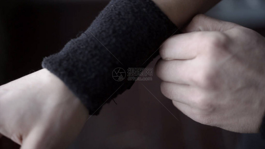 运动员佩戴黑色腕带行动运动员的特写镜头调整他手上的腕带图片