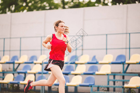 女运动员在体育场跑道上慢跑图片