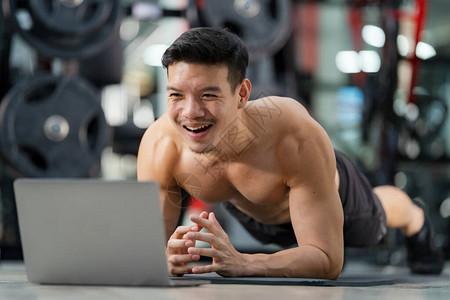 在线训练运动男子训练在健身房用笔记本电脑图片