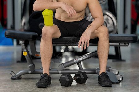 运动型男子在健身房用哑铃训练图片