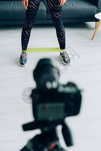 家庭数码相机附近站立的双腿上有抗力波带的女运动员选图片