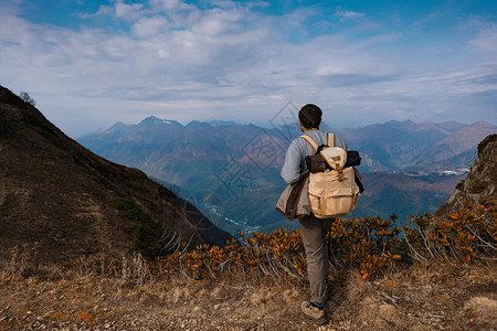 秋天在山上的年轻男时髦发现旅游目的地概念高岩石背景上的游客体育和积图片