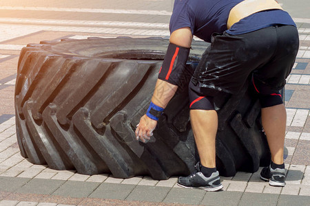 体育运动员在交叉健身时翻轮胎在户外图片