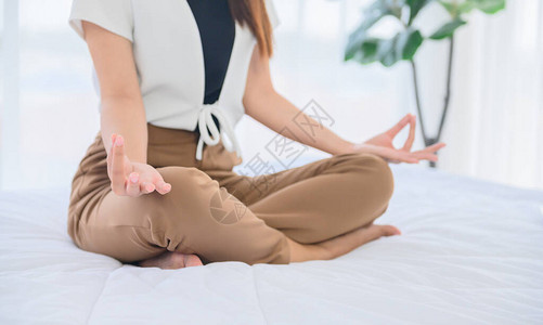 亚洲女瑜伽呼吸和独自在家冥想在床上放松健康的生活方式体育和图片