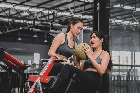 亚洲女在健身房锻炼和生活方式运动型女人与教练一起锻炼图片