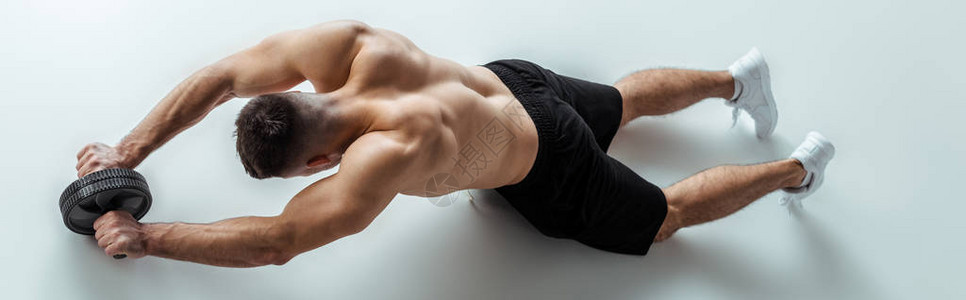 感肌肉健壮体建房者光裸的躯体锻炼在灰色背景图片