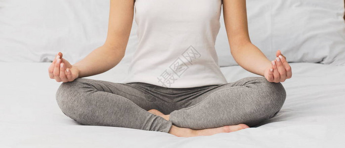妇女醒来后在床上做瑜伽缝图片