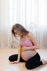 一个怀孕的女孩在家做瑜伽健康图片