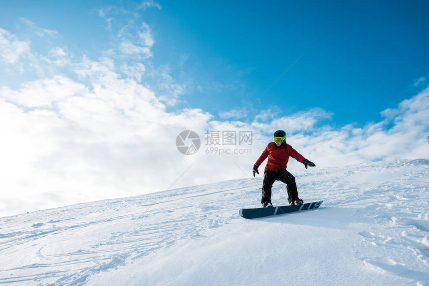 穿戴头盔的运动滑雪机在斜坡上骑行用图片