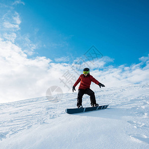 穿戴头盔的滑雪车在斜图片