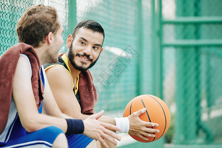 积极的篮球运动员在听朋友谈论游戏或传播新闻时图片