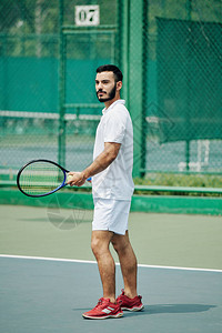 穿白运动服装在户外打网球的英俊西图片