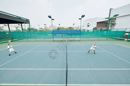 在野外法庭上玩网球游戏的白图片