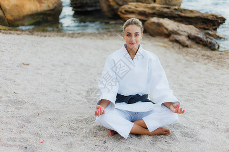 年轻有吸引力的女拳手在白色和服的白人女斗士中带背景图片