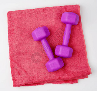 二对紫色塑料哑铃和粉红色毛巾图片