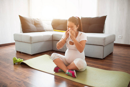 一位孕妇在家里的瑜伽垫上锻炼怀孕和运动奥加和普拉提孕妇怀孕的图片
