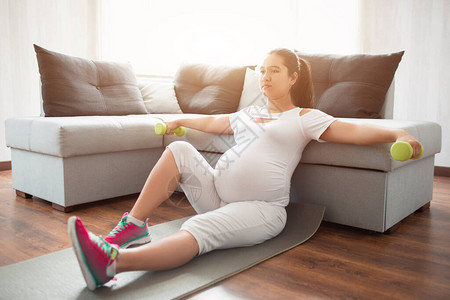 孕妇坐在瑜伽垫子上图片