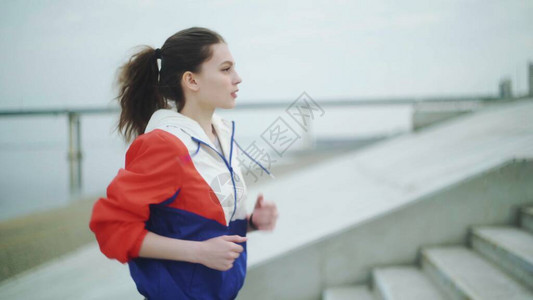 适合的年轻女子跑上楼梯的侧面图女运动员跑图片