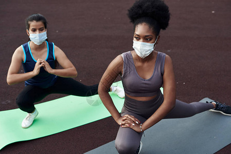 黑人女孩和高加索女孩戴保护面罩到户外运动图片