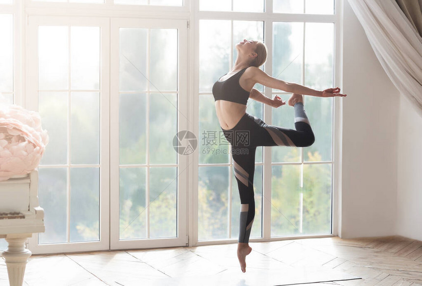 年轻漂亮的芭蕾舞女青年在工作室运动用大窗户和钢图片