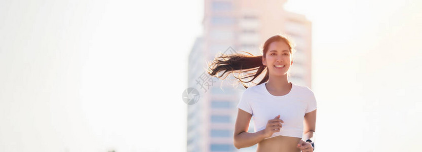 微笑的亚洲年轻健身运动女在城市地区跑步和运动型人训练健康的生活方图片