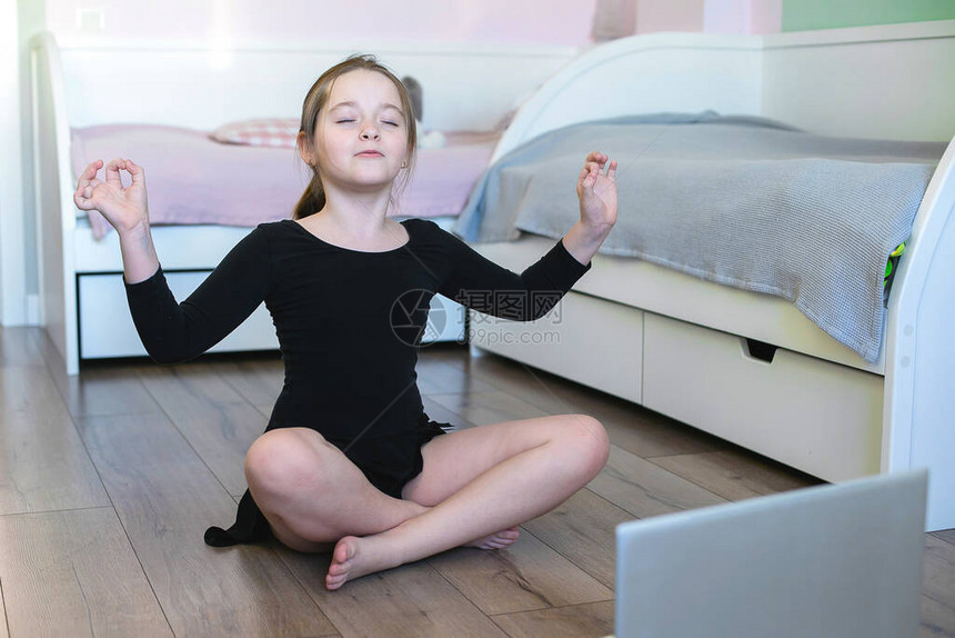 女学生在笔记本电脑上观看在线视频并进行体育锻炼瑜伽体操舞蹈呆在家里自我隔离隔离在图片