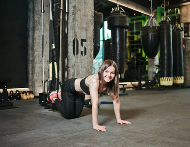 年轻女子在健身房做俯卧撑双腿图片