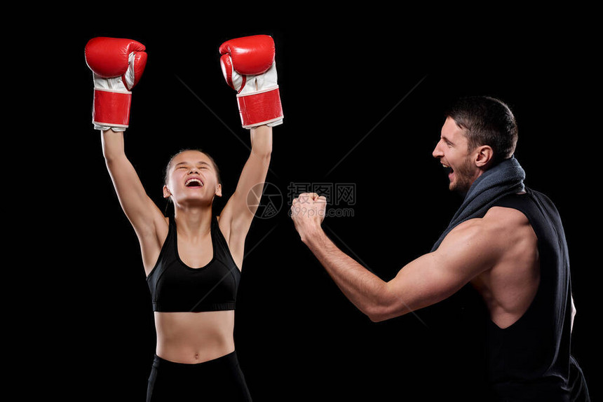 参加拳击手套和运动服的欣鼓舞的年轻运动员女运动员及其教练在成功比图片