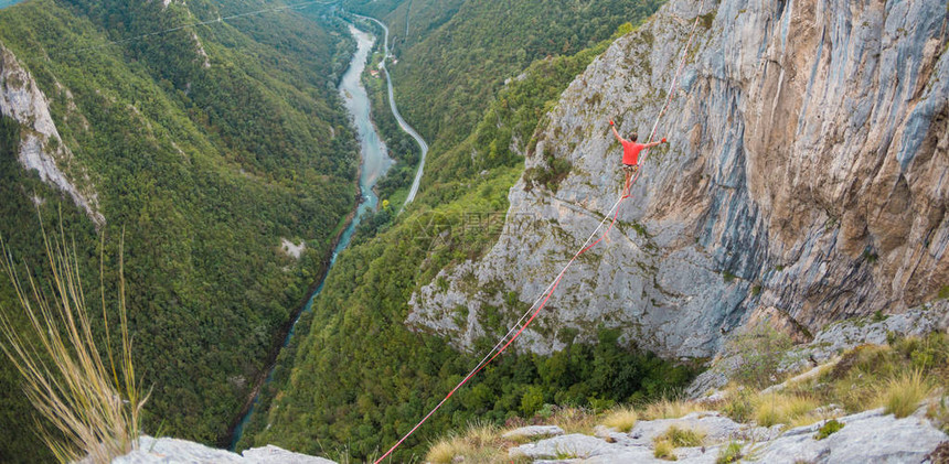 山中的高线一个人在伸展的吊索上前进Highline上线了走钢丝的人保持平衡平衡对紧张图片