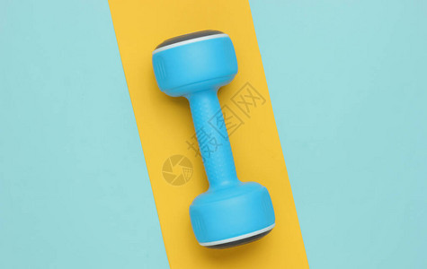 蓝黄纸背景的塑料哑铃Minimalism健身概念图片