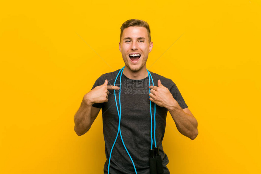 年轻caucasian男子拿着跳绳惊讶地指着自己图片