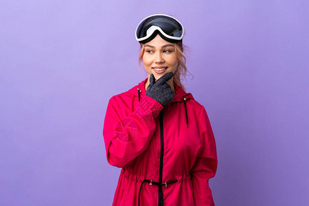 穿着滑雪眼镜的滑雪少女与孤立的紫色背景隔绝仰图片