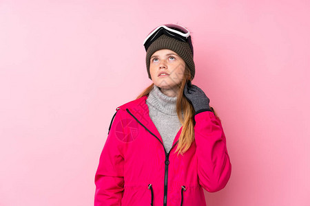 带着滑雪眼镜的乌克兰青少年滑雪女孩与孤立的粉红背景图片