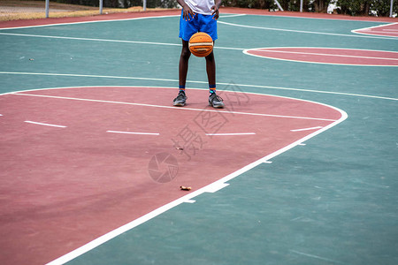 拍摄在篮球场投球的年轻男孩背景图片