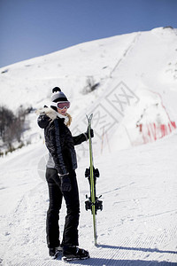 带着滑雪设备在山度假胜地渡冬假的图片