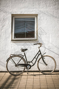 路边复古自行车与老式混凝土白墙背景图片