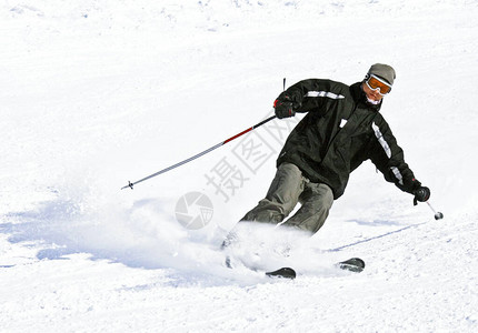 雪旋风中的滑雪者在滑雪场转弯时被雪图片
