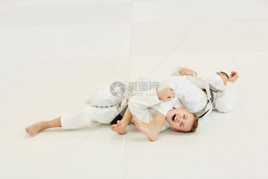 两名身穿白和服的柔道主义者躺在地上图片