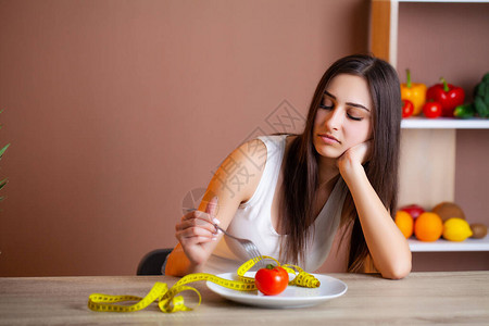 青春美丽的年轻女人的肖像番茄和测量图片