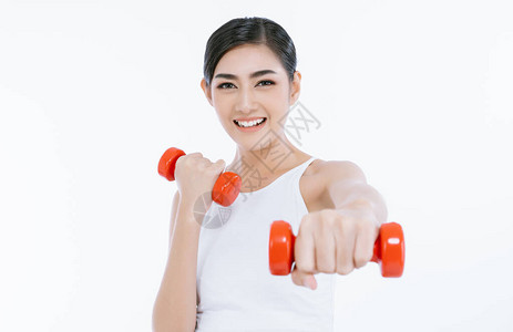 美丽的亚洲年轻健身女举起哑铃图片