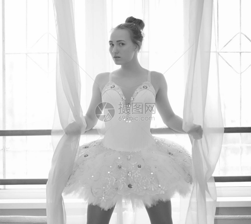 年轻的芭蕾舞演员在热身芭蕾舞演员正准备在演播室演出一个穿着芭蕾舞服和鞋子的女孩图片