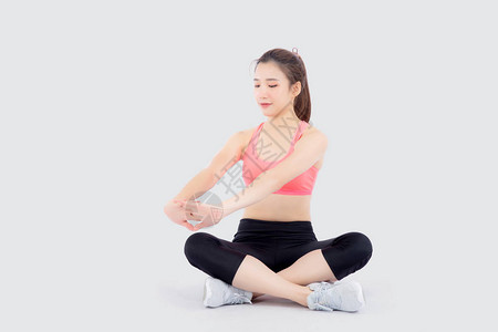 美丽的年轻亚洲女在运动中坐着伸展肌肉手臂锻炼与健康隔离在白色背景上图片