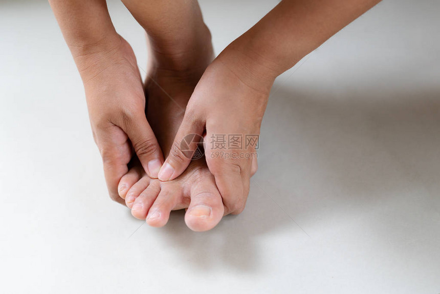 妇女按摩其痛苦的脚和手指保健和医疗图片