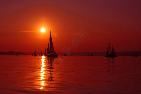 在开阔水域和日落中的帆船图片