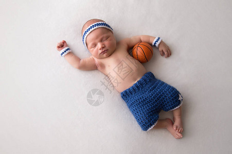 10天大的新生儿男孩身穿篮球短裤和汗带图片