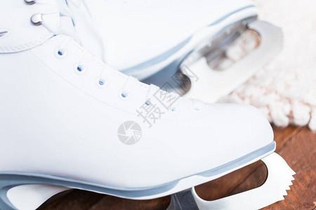 近景木板上的新白色花样滑冰鞋背景图片