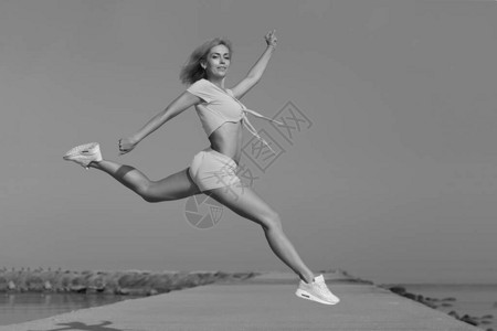 跳跃的年轻苗条运动女孩图片