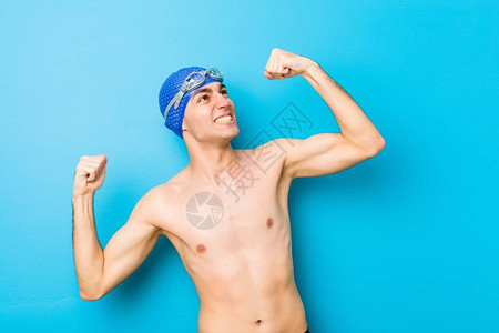 游泳的年轻男子在胜利后举拳图片