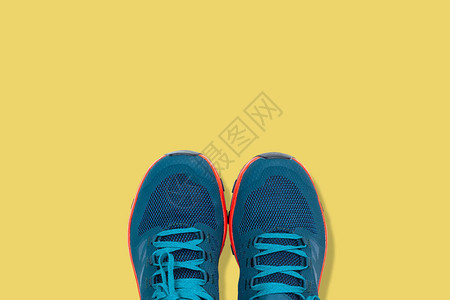 黄色背景上的蓝色运动鞋图片
